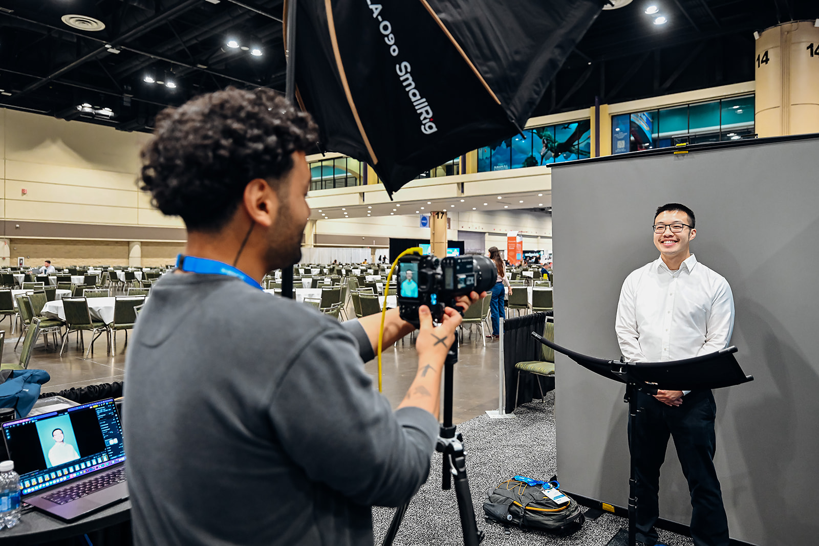 Headshot session in progress with tethered laptop station on the expo floor