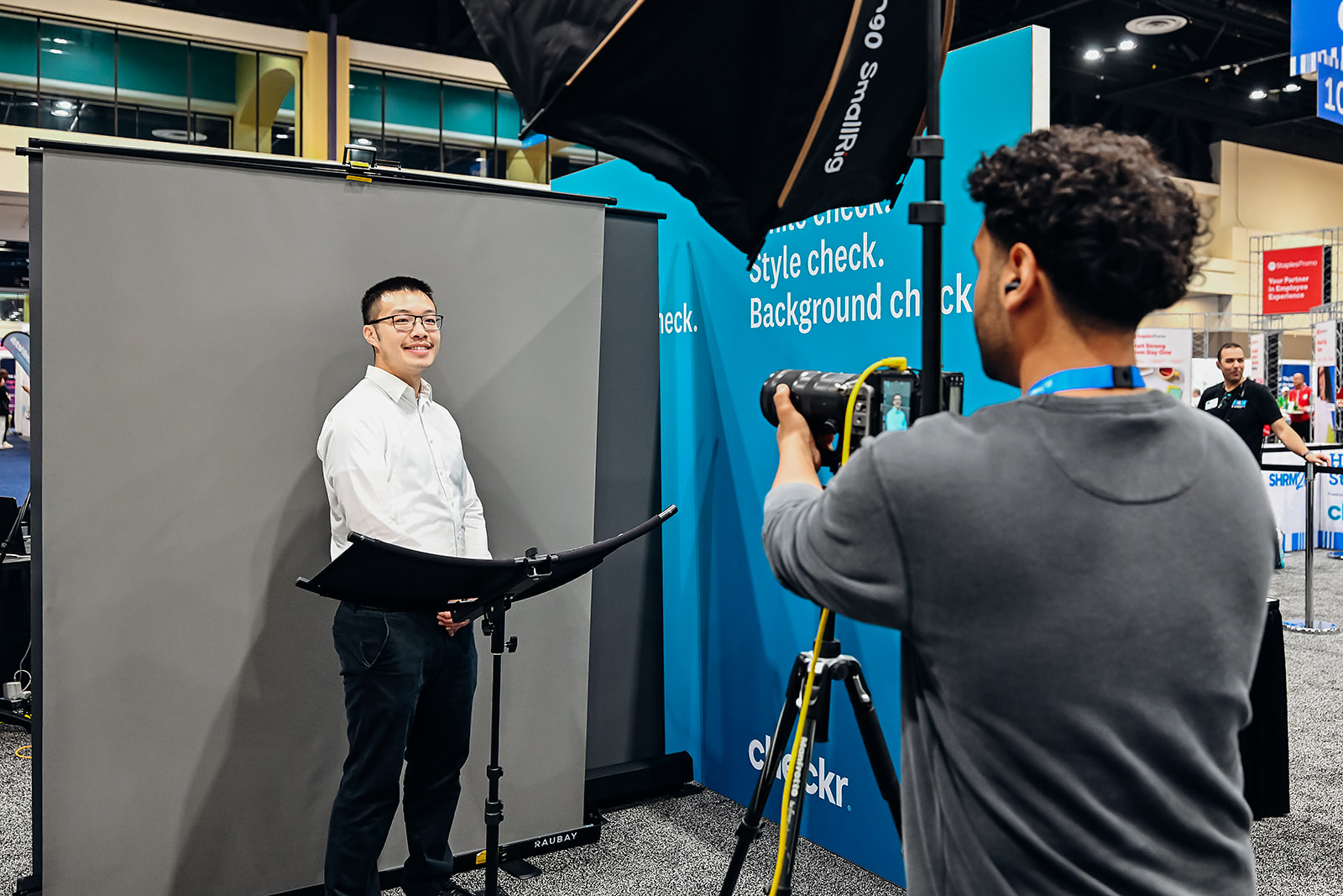 RTW photographer directing a guest through a headshot session at a conference lounge